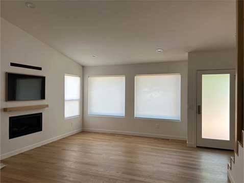 Living room space showcasing two large windows with shades