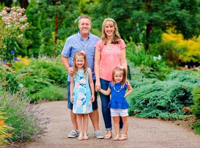 A small family standing together in a garden